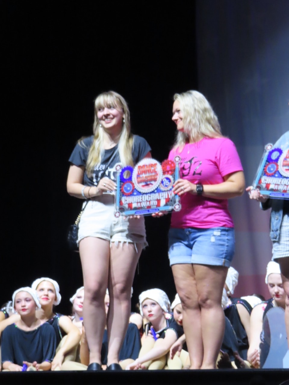 Turn Out Dance Academy instructor and dancer holding a choreography award on stage