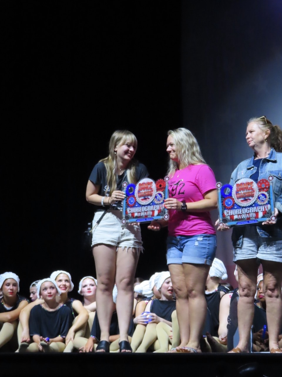 Turn Out Dance Academy instructors receiving choreography awards on stage