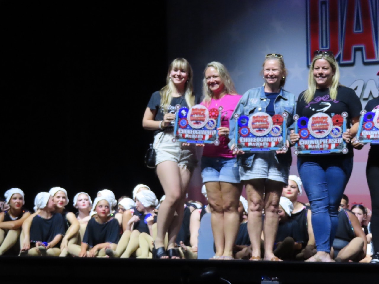 Turn Out Dance Academy team and instructors holding choreography awards on stage