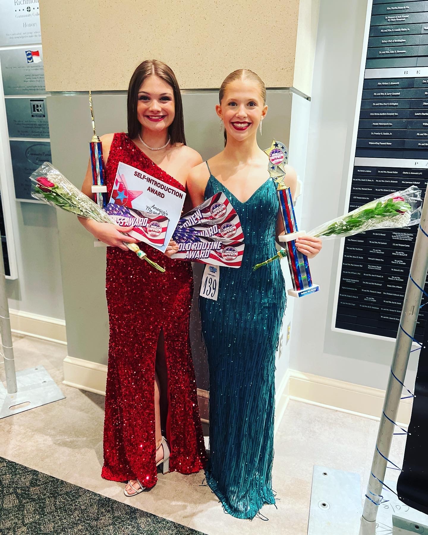 Two Turn Out Dance Academy performers holding trophies and award certificates