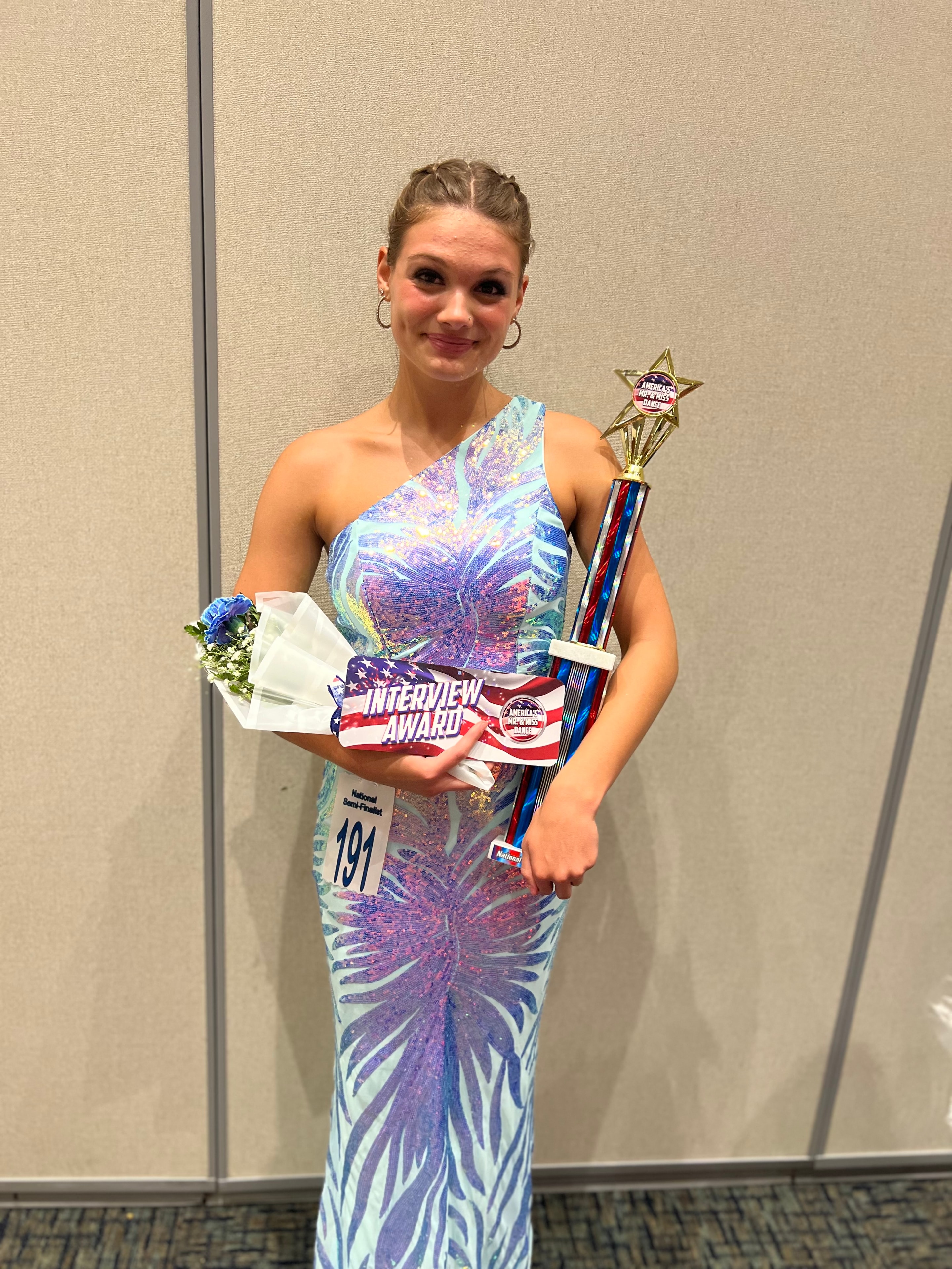 Award-winning Turn Out Dance Academy performer holding a trophy and bouquet