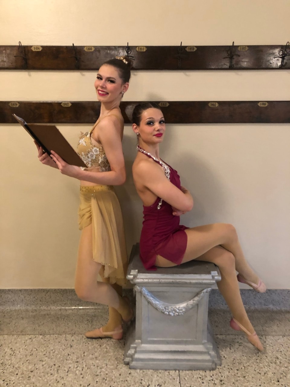 Two dancers posing together backstage in performance costumes