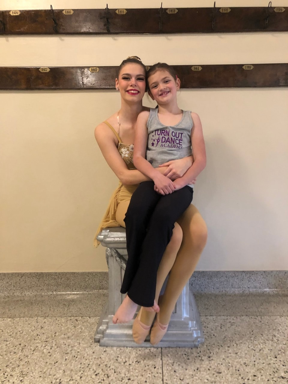A dancer sharing a candid backstage moment with a young Turn Out Dance Academy student