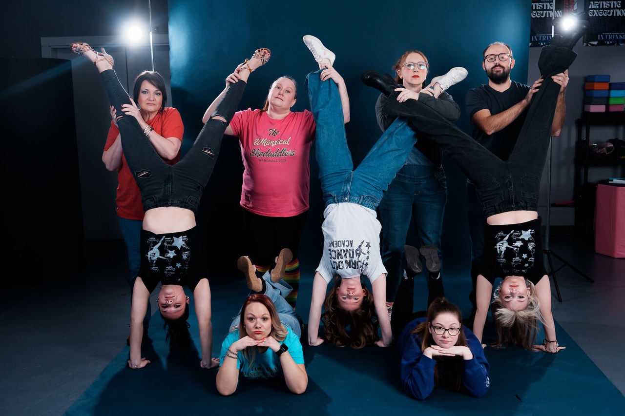 Turn Out Dance Academy staff and dancers sharing a playful handstand pose