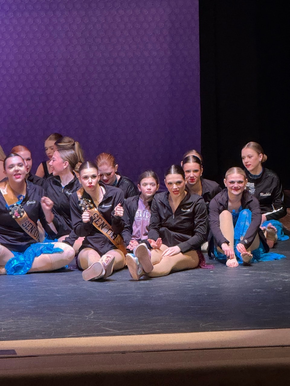 Turn Out Dance Academy dancers sharing a candid group moment on stage