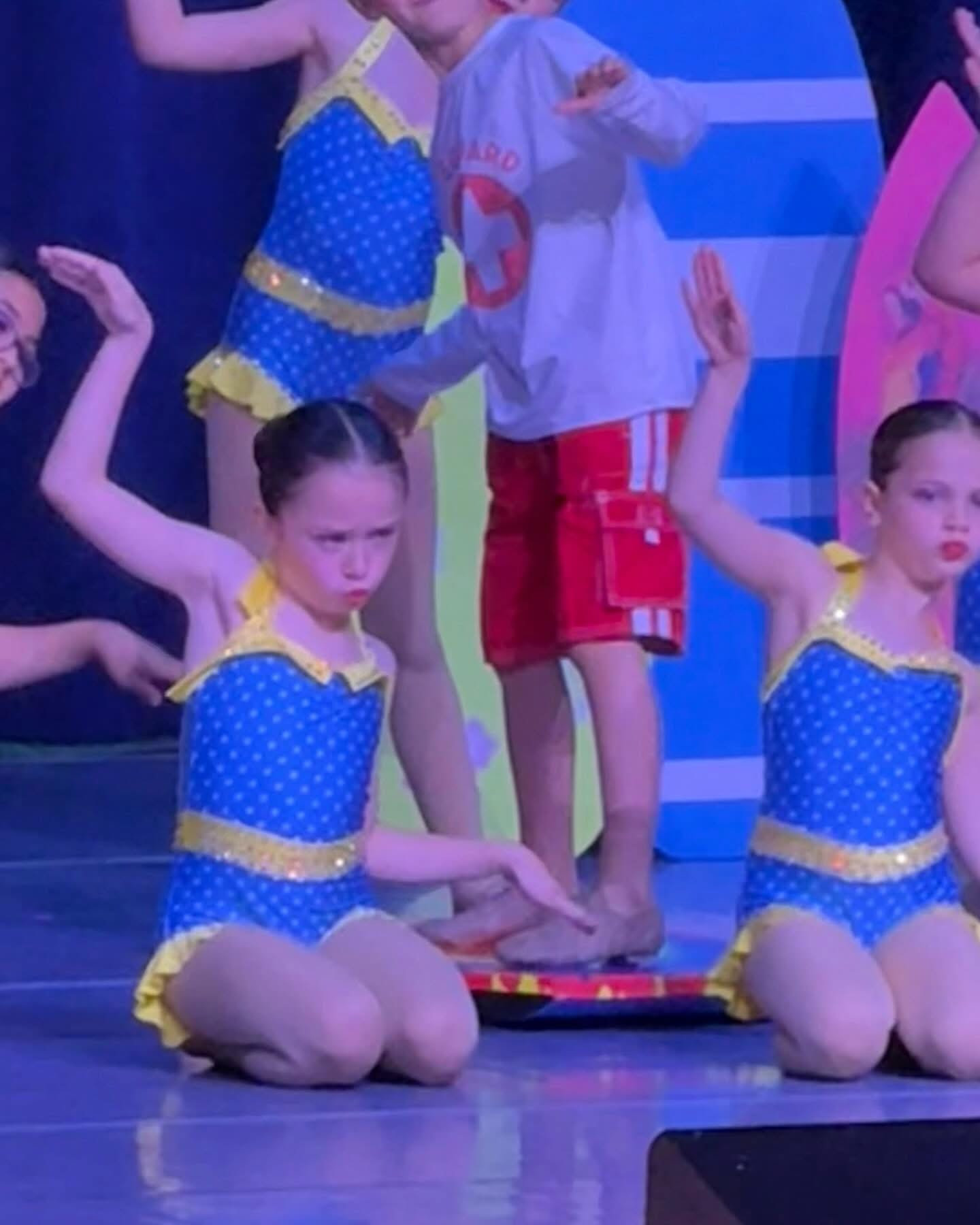 Young dancers performing in blue costumes on stage