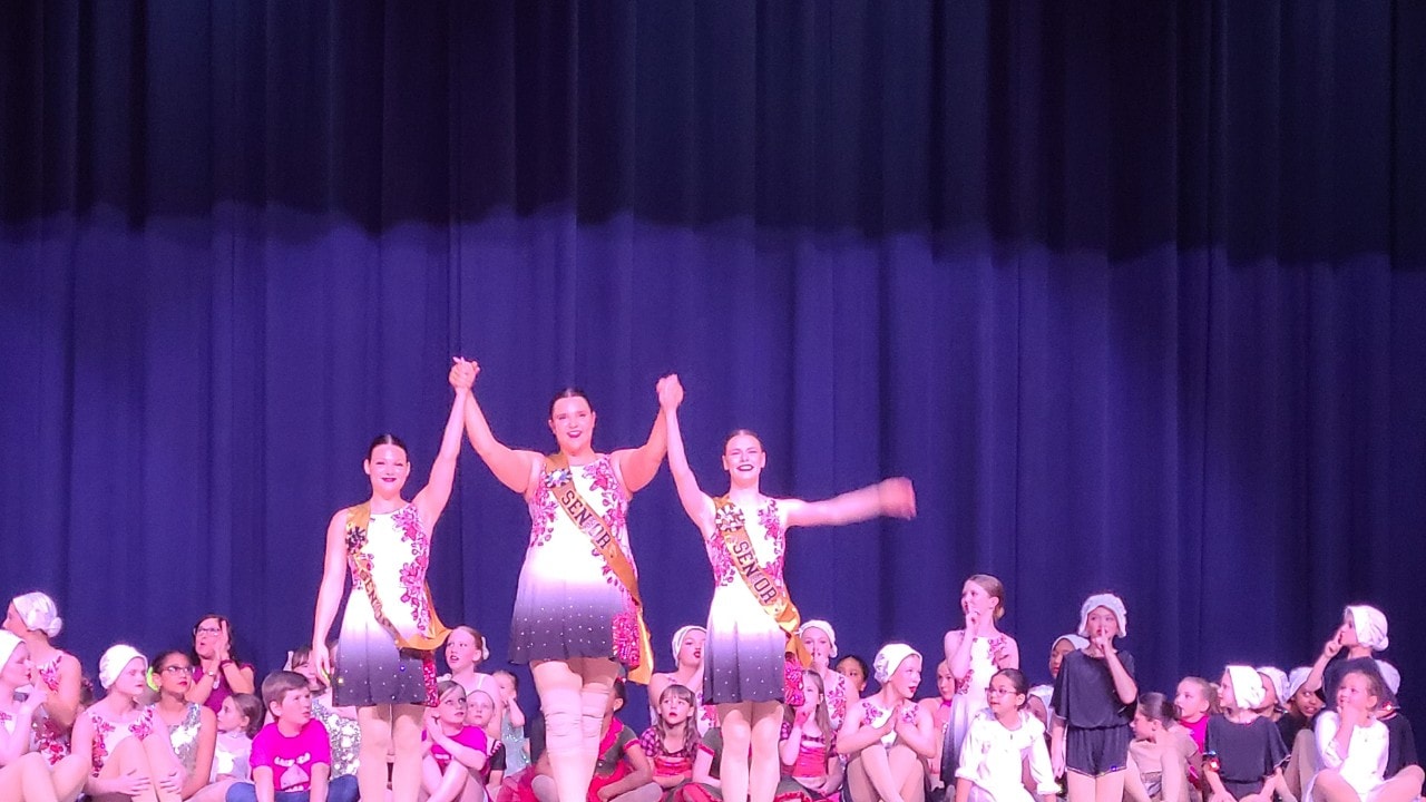 Turn Out Dance Academy performers celebrating together on stage at curtain call