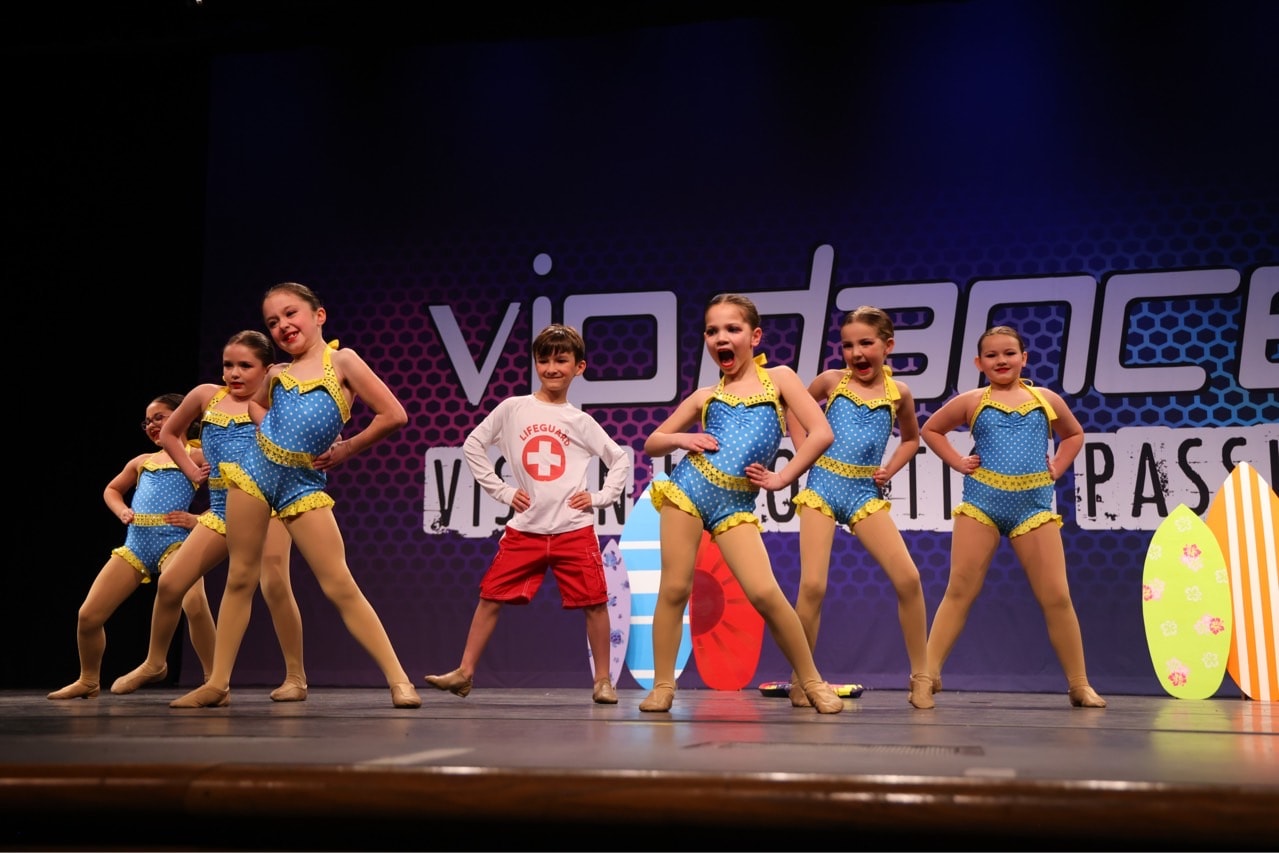 Young dancers performing in colorful summer costumes on stage