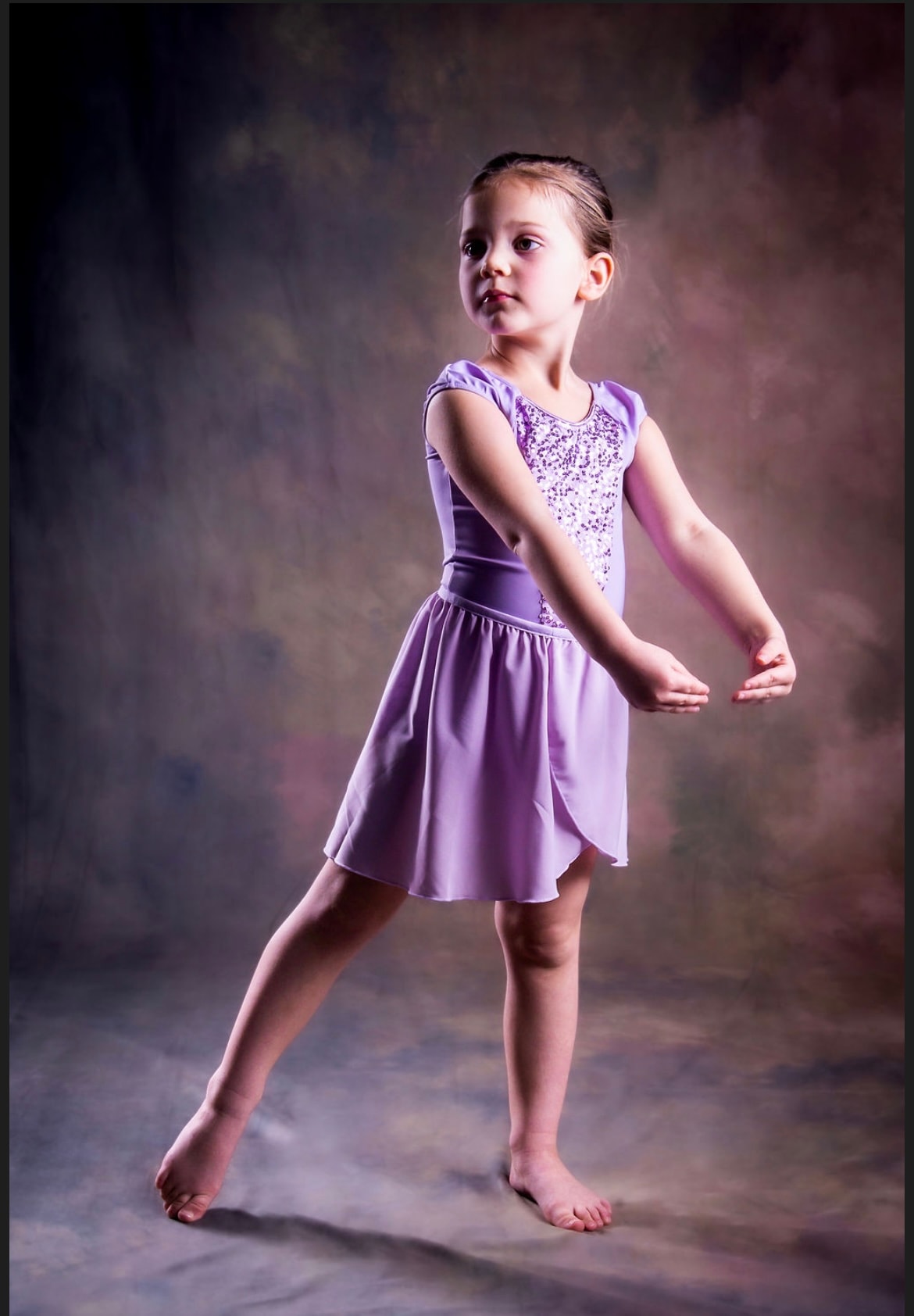 Young ballet dancer posing in a lavender costume