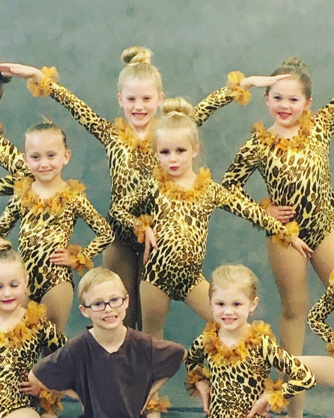 Young dancers posing in coordinated leopard-print recital costumes